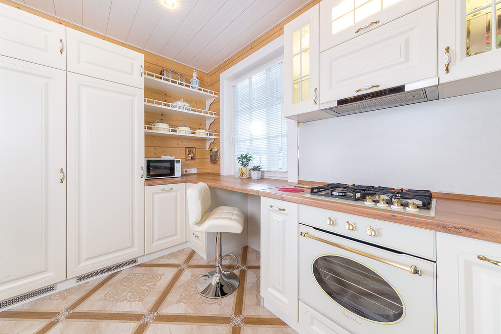 This is an example of a small transitional u-shaped eat-in kitchen in Saint Petersburg with a drop-in sink, recessed-panel cabinets, white cabinets, wood benchtops and no island.