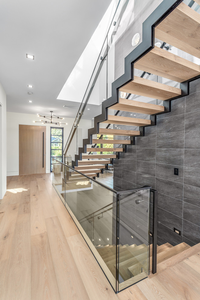 This is an example of a mid-sized contemporary wood straight staircase in Vancouver with metal railing.