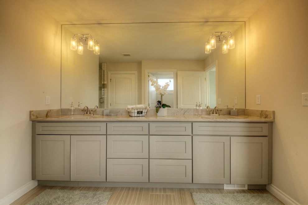 Photo of a mid-sized transitional master bathroom in Detroit with shaker cabinets, beige cabinets, an alcove shower, brown walls, porcelain floors, an undermount sink, marble benchtops, brown floor, a hinged shower door and brown benchtops.