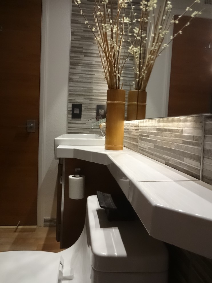 Mid-sized asian master bathroom in Orange County with raised-panel cabinets, beige cabinets, a one-piece toilet, red tile, porcelain tile, grey walls, vinyl floors, a trough sink, quartzite benchtops, beige floor, white benchtops, an enclosed toilet, a single vanity and a floating vanity.