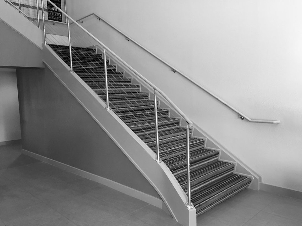 アトランタにあるラグジュアリーな巨大なモダンスタイルのおしゃれなかね折れ階段 (カーペット張りの蹴込み板) の写真