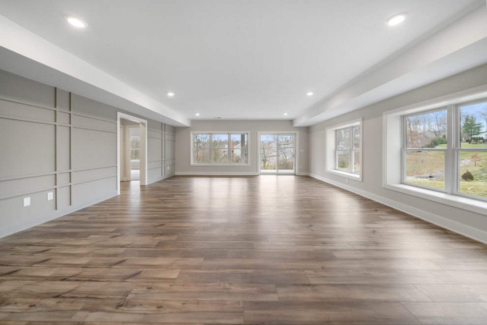 Inspiration for a large transitional walk-out wall paneling basement remodel in Cincinnati with a bar
