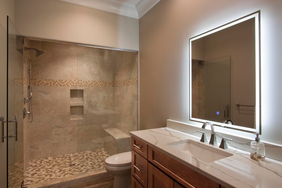 Photo of a large transitional kids bathroom in Other with brown cabinets, slate, marble benchtops, a hinged shower door, shaker cabinets, an alcove shower, a two-piece toilet, brown tile, brown walls, pebble tile floors, an undermount sink and brown floor.