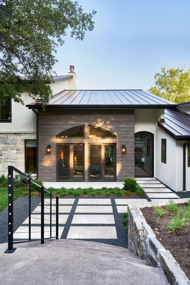 Inspiration pour une façade de maison traditionnelle à un étage avec un toit en métal et un toit marron.