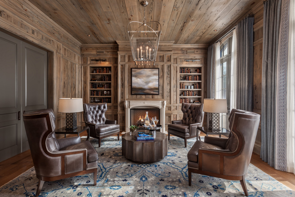 Transitional study room in Other with brown walls, medium hardwood floors, a standard fireplace, a stone fireplace surround, brown floor, wood, panelled walls and wood walls.