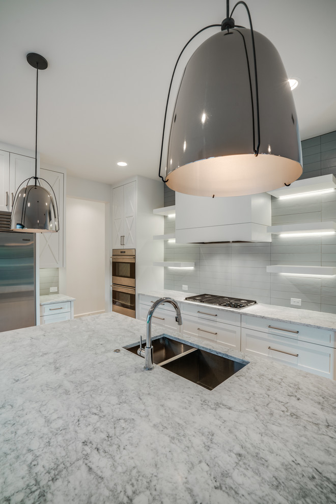 Kitchen - large transitional single-wall light wood floor kitchen idea in Dallas with a double-bowl sink, shaker cabinets, white cabinets, marble countertops, white backsplash, an island and stainless steel appliances