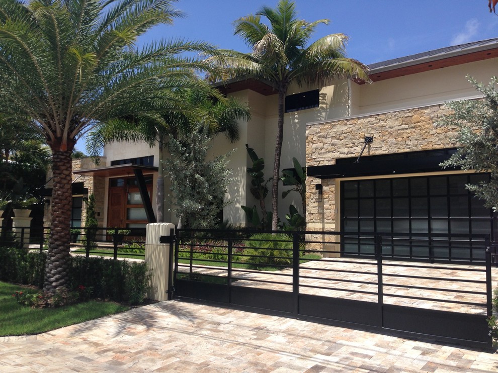 Photo of a mid-sized contemporary two-storey beige exterior in Miami with stone veneer.