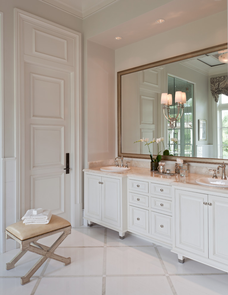 Photo of a beach style master bathroom in Boston with a drop-in sink, raised-panel cabinets, white cabinets, an alcove shower and beige walls.
