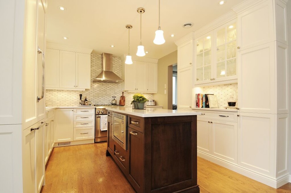 Example of a mid-sized transitional l-shaped medium tone wood floor kitchen design in Ottawa with a double-bowl sink, recessed-panel cabinets, white cabinets, quartz countertops, gray backsplash, stone tile backsplash, stainless steel appliances and an island
