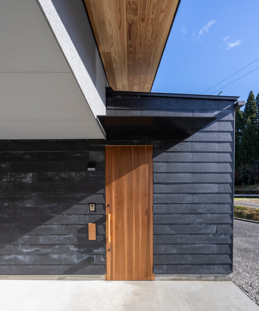 Свежая идея для дизайна: входная дверь в стиле модернизм с серыми стенами, бетонным полом, одностворчатой входной дверью, входной дверью из темного дерева, серым полом, деревянным потолком и панелями на стенах - отличное фото интерьера
