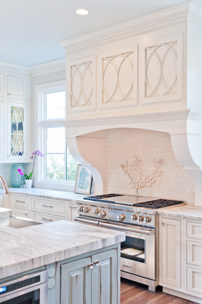 Design ideas for a large beach style u-shaped eat-in kitchen in Jacksonville with a farmhouse sink, beaded inset cabinets, white cabinets, marble benchtops, white splashback, glass sheet splashback, panelled appliances, dark hardwood floors and with island.