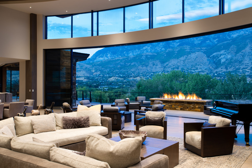 Inspiration for an expansive world-inspired formal open plan living room in Salt Lake City with white walls, medium hardwood flooring, a two-sided fireplace, a stone fireplace surround, a wall mounted tv, brown floors, a coffered ceiling and wood walls.
