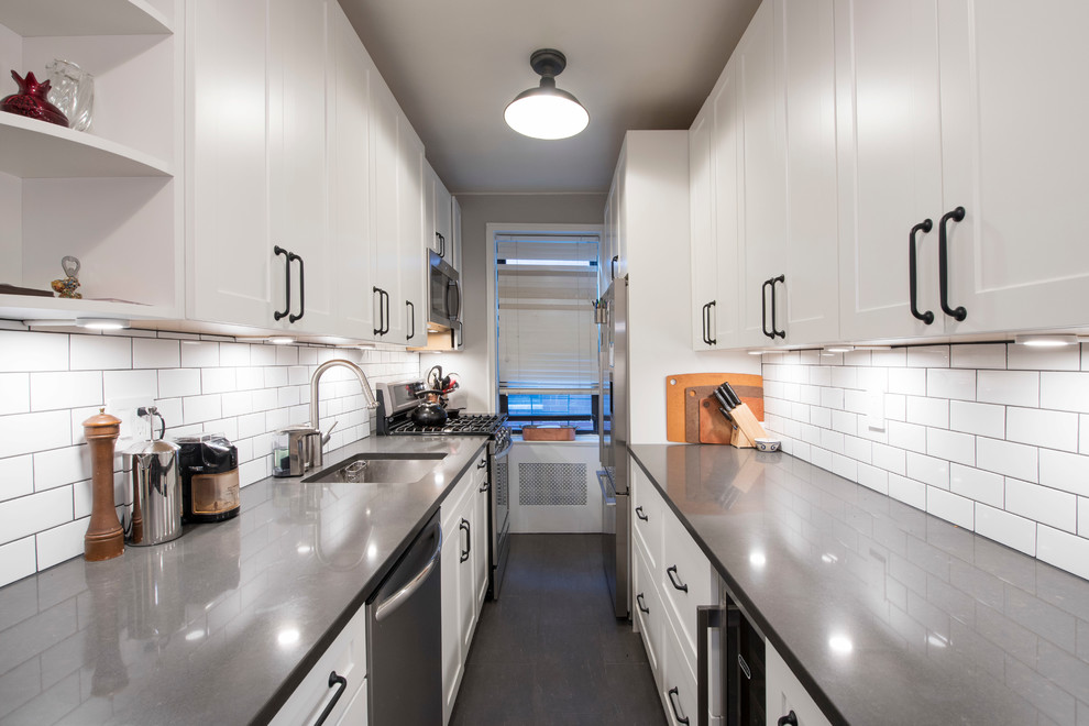 Design ideas for a small modern galley separate kitchen in New York with an undermount sink, shaker cabinets, white cabinets, white splashback, subway tile splashback, stainless steel appliances, vinyl floors and no island.