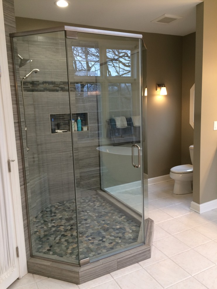 Photo of a large classic ensuite bathroom in Milwaukee with raised-panel cabinets, white cabinets, a freestanding bath, a corner shower, a two-piece toilet, grey tiles, porcelain tiles, grey walls, porcelain flooring, a submerged sink and granite worktops.
