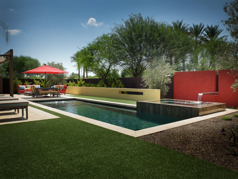 Design ideas for a mid-sized contemporary backyard rectangular pool in Phoenix with a water feature and tile.