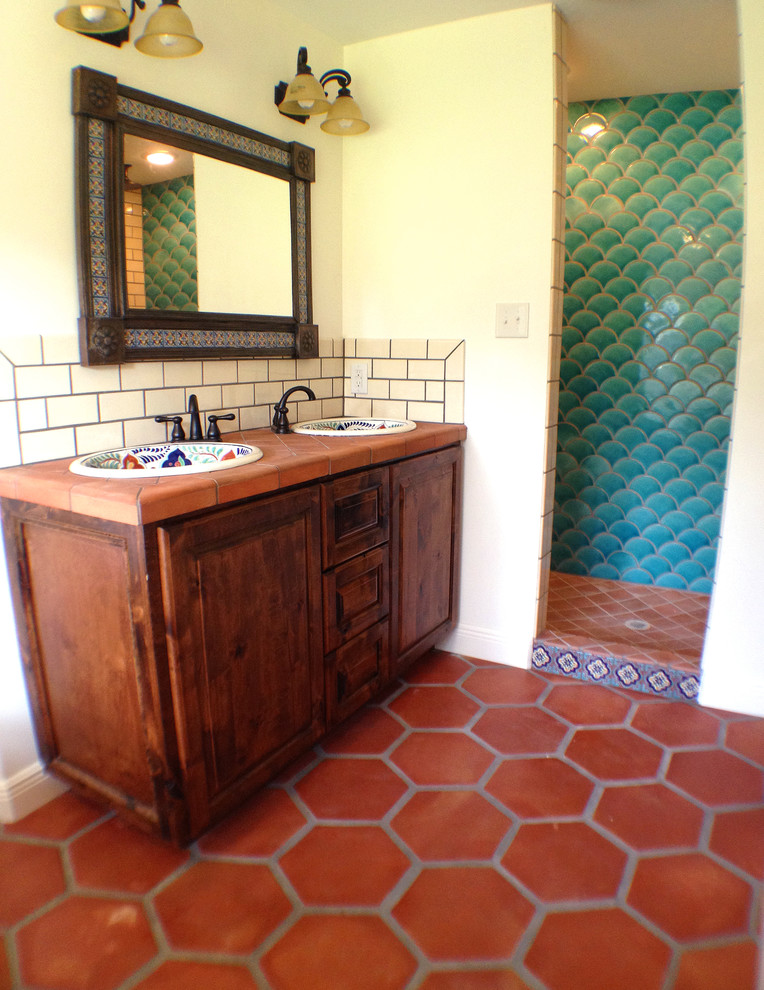 This is an example of a traditional master bathroom in Austin with a drop-in sink, raised-panel cabinets, medium wood cabinets, tile benchtops, a claw-foot tub, an open shower, a two-piece toilet, terra-cotta tile, white walls and terra-cotta floors.