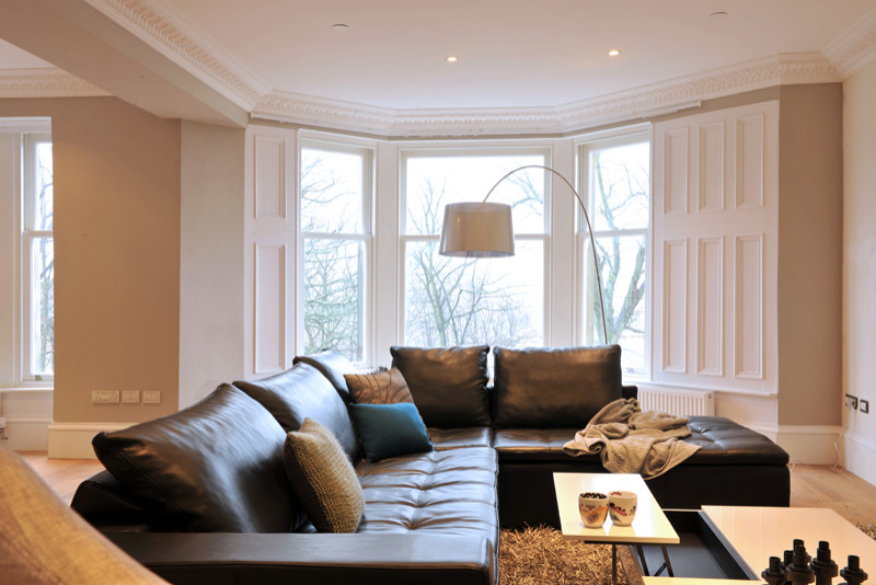 This is an example of a mid-sized contemporary formal open concept living room in Glasgow with beige walls, light hardwood floors and a built-in media wall.