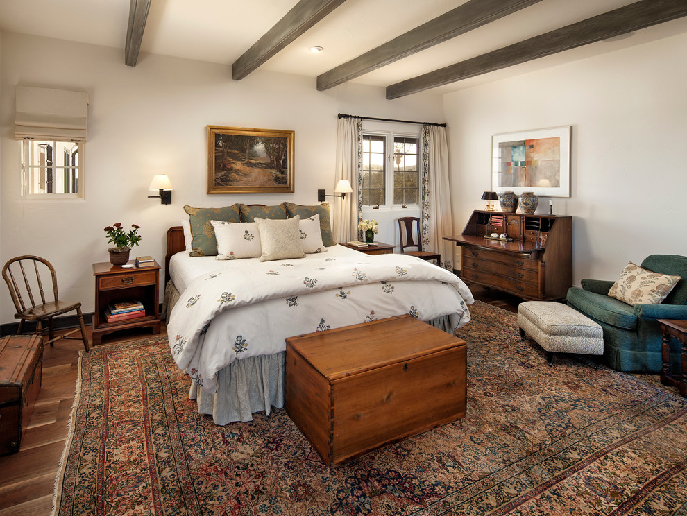 Design ideas for a mid-sized mediterranean master bedroom in Santa Barbara with white walls, dark hardwood floors and no fireplace.