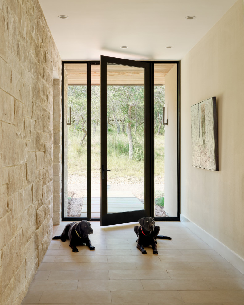 Foto de puerta principal moderna de tamaño medio con paredes beige, suelo de piedra caliza, puerta simple, puerta de vidrio y suelo beige