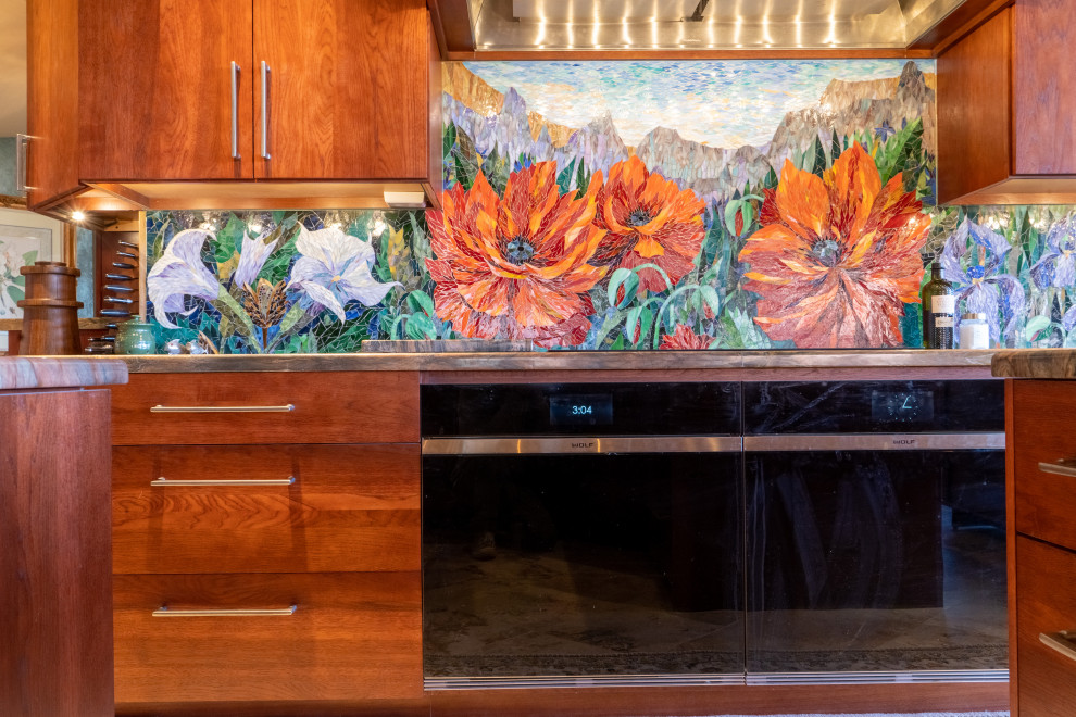 Kitchen - eclectic kitchen idea in Phoenix with flat-panel cabinets, red cabinets, granite countertops, glass tile backsplash, paneled appliances and an island