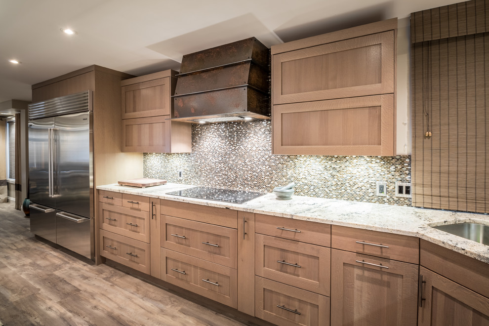 Example of a transitional l-shaped vinyl floor eat-in kitchen design with an undermount sink, shaker cabinets, light wood cabinets, granite countertops, brown backsplash, mosaic tile backsplash, stainless steel appliances and an island