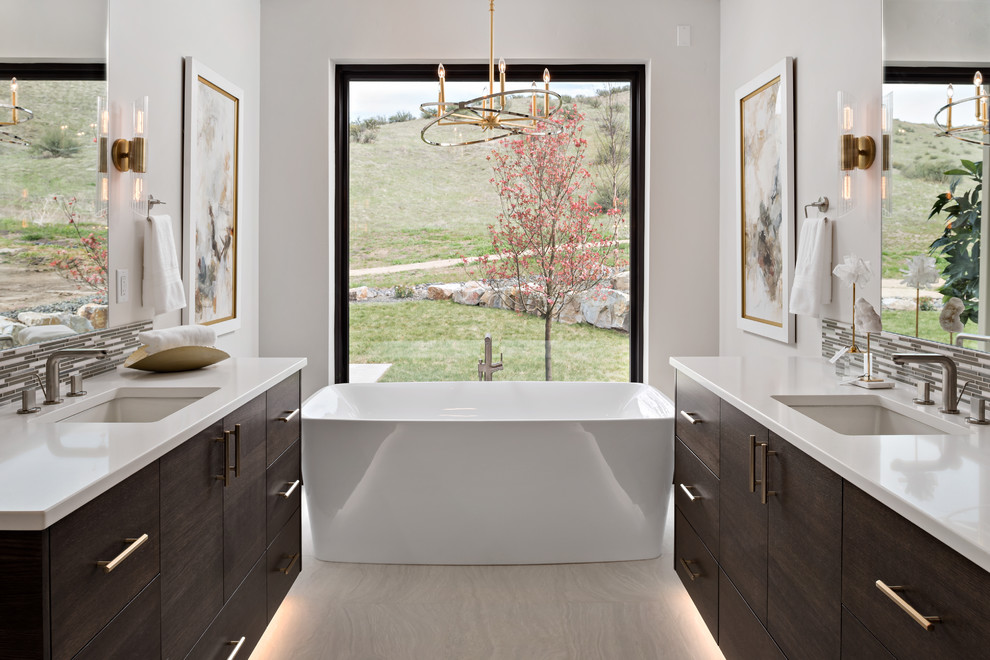 Inspiration for a contemporary master bathroom in Boise with flat-panel cabinets, dark wood cabinets, a freestanding tub, gray tile, matchstick tile, white walls, an undermount sink, beige floor and white benchtops.
