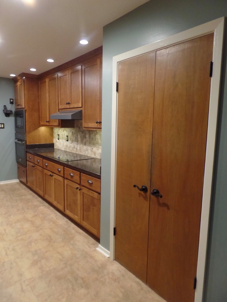 Eat-in kitchen - mid-sized transitional galley eat-in kitchen idea with an undermount sink, shaker cabinets, medium tone wood cabinets, quartz countertops, multicolored backsplash, travertine backsplash, colored appliances and no island