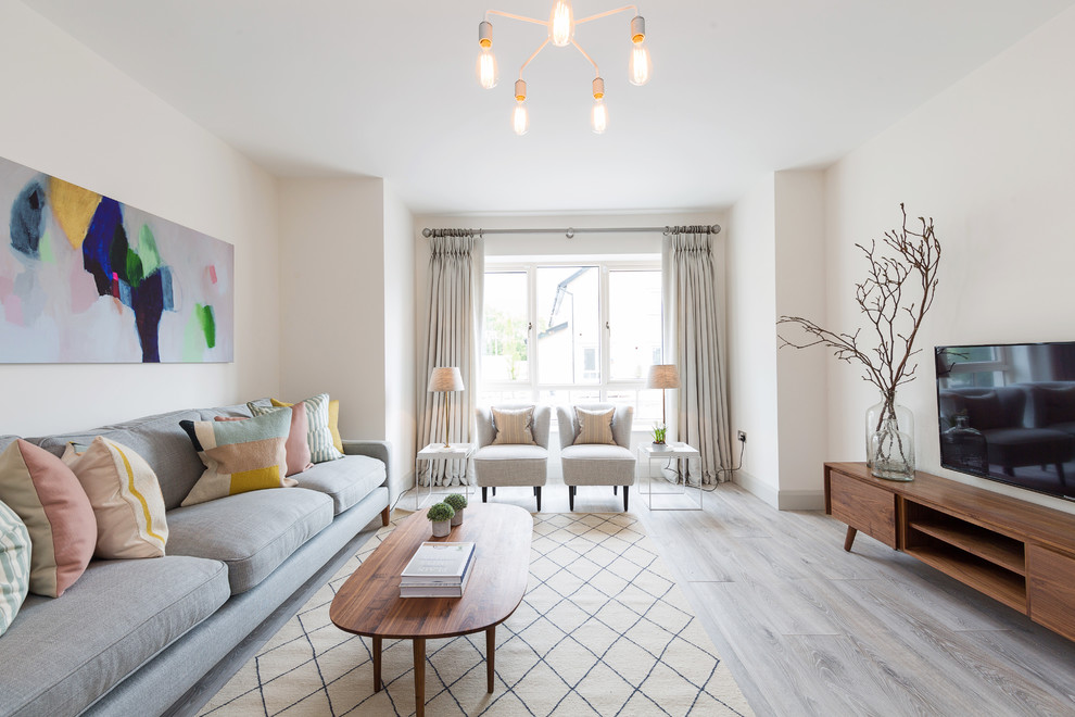 Design ideas for a mid-sized transitional family room in Dublin with white walls, light hardwood floors and grey floor.