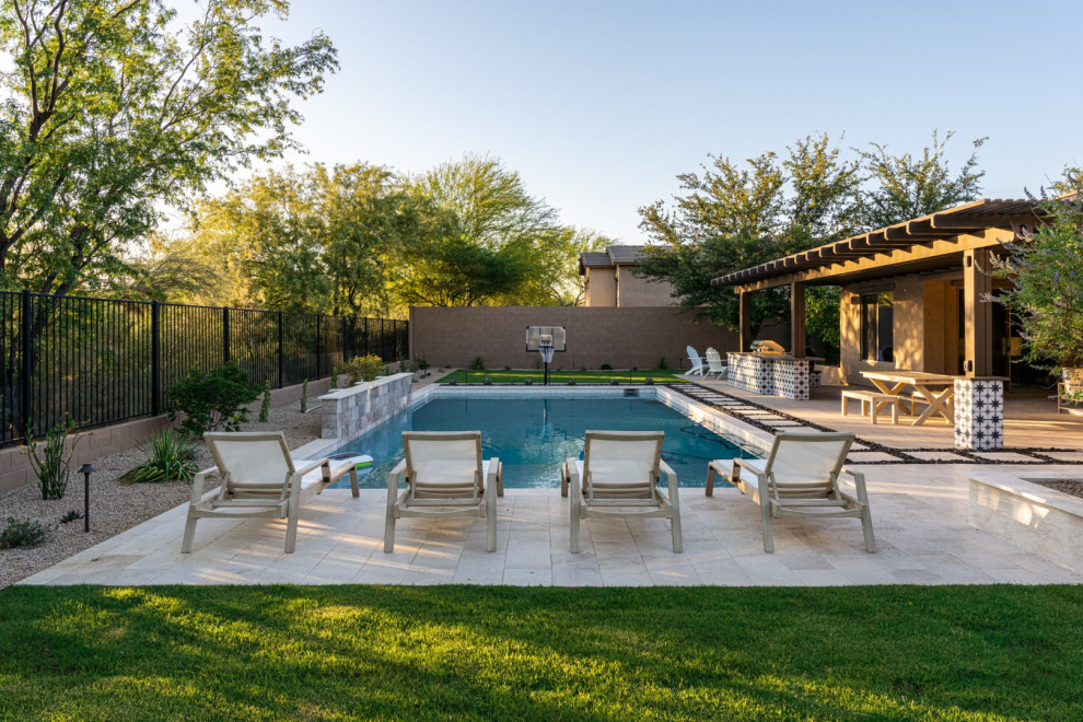 Example of a mid-sized transitional backyard stone and rectangular pool landscaping design in Phoenix