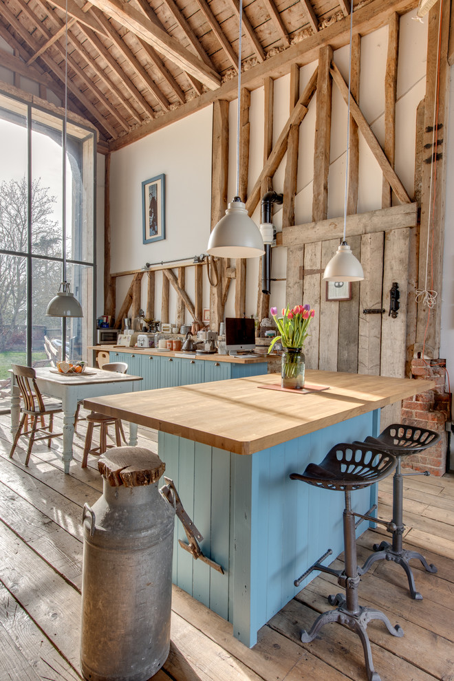 Design ideas for a country kitchen in Other with blue cabinets.