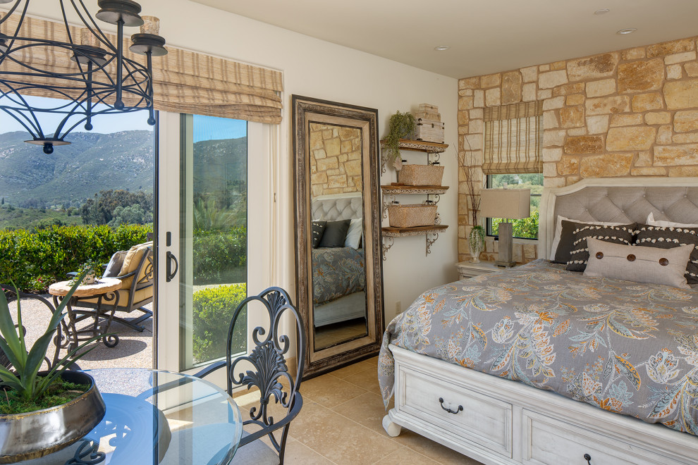 Imagen de habitación de invitados de estilo americano extra grande con paredes beige, suelo de piedra caliza, suelo beige y vigas vistas
