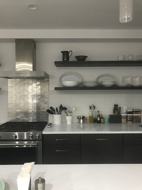 Contemporary kitchen in New York with metal splashback.