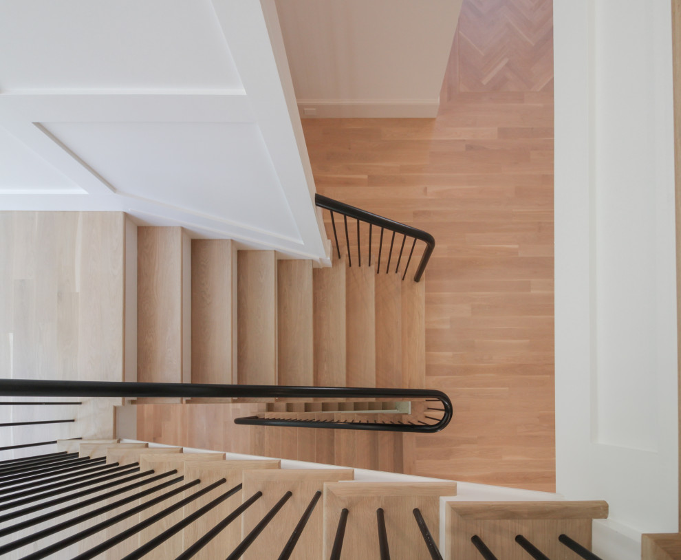 Diseño de escalera en U minimalista grande con escalones de madera, contrahuellas de madera pintada, barandilla de varios materiales y boiserie