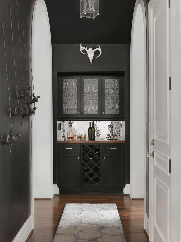 Inspiration for a mid-sized transitional single-wall wet bar in St Louis with an undermount sink, glass-front cabinets, black cabinets, wood benchtops, mirror splashback, dark hardwood floors, brown floor and brown benchtop.