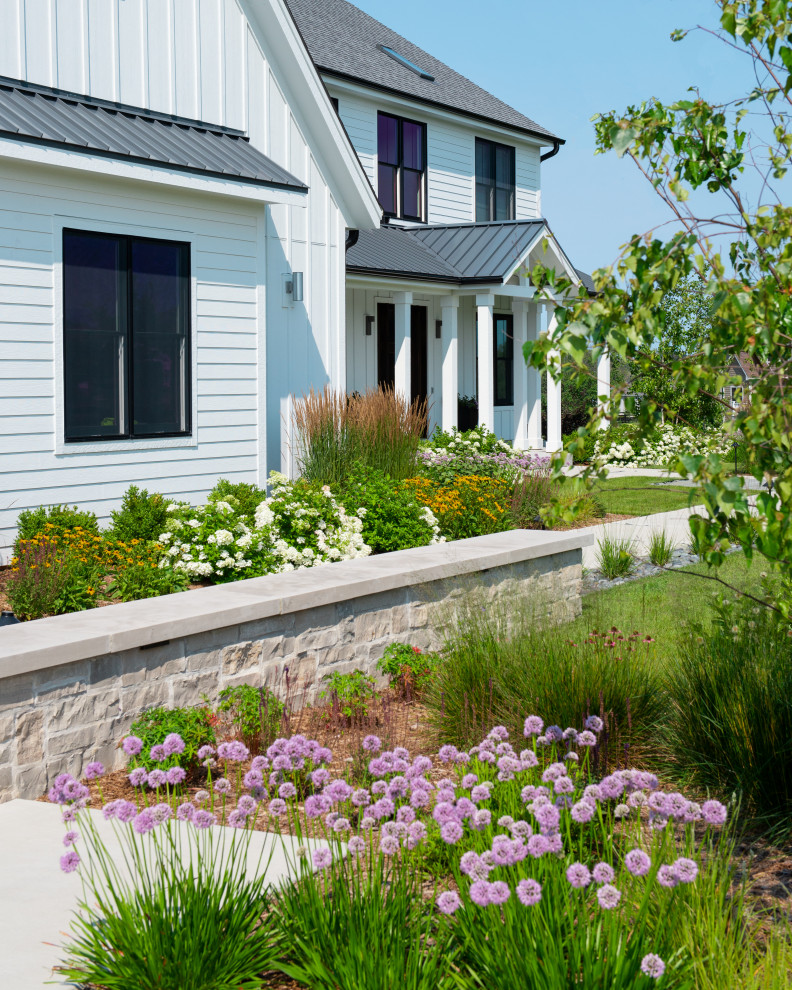 Photo of a large farmhouse front full sun garden in Milwaukee with a pathway.