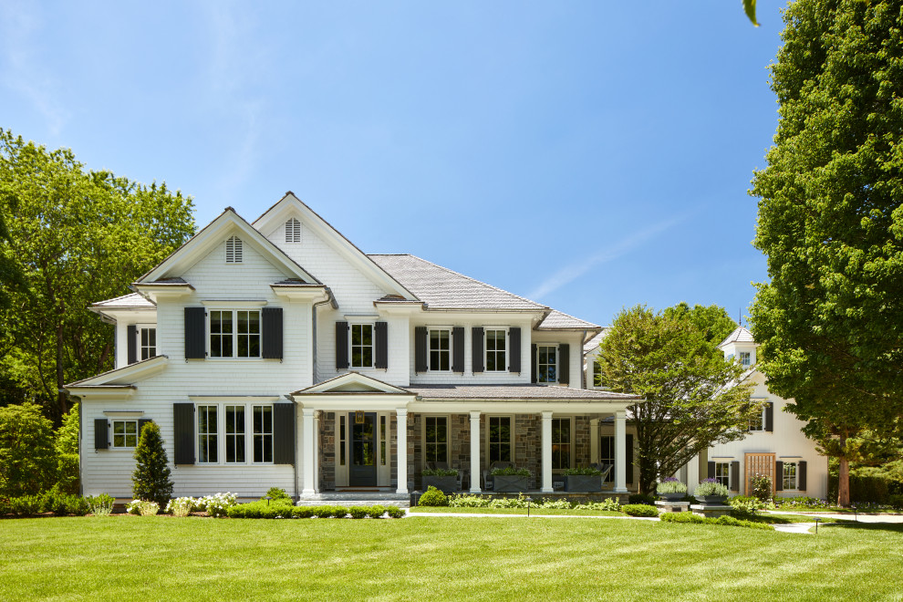Immagine della villa grande beige country a due piani con rivestimento in legno, copertura a scandole, tetto marrone e con scandole