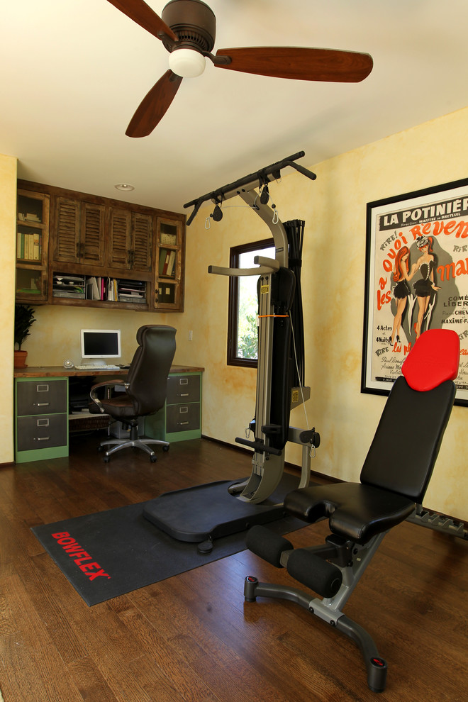 Inspiration for a small mediterranean multipurpose gym in Los Angeles with beige walls, dark hardwood floors and brown floor.