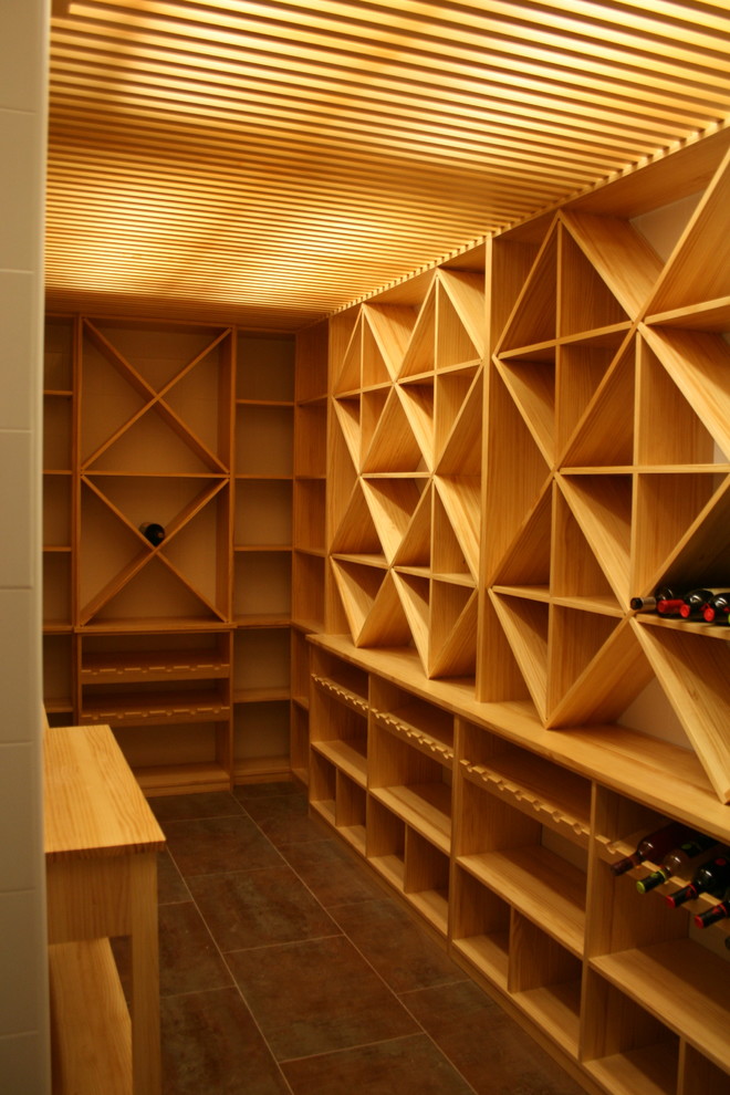 This is an example of a mid-sized contemporary wine cellar in Other with diamond bins.