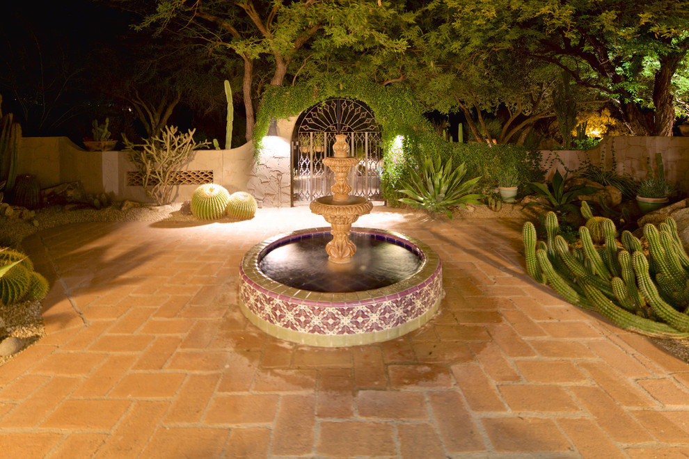 Photo of a large mediterranean backyard custom-shaped natural pool in Phoenix with concrete pavers.