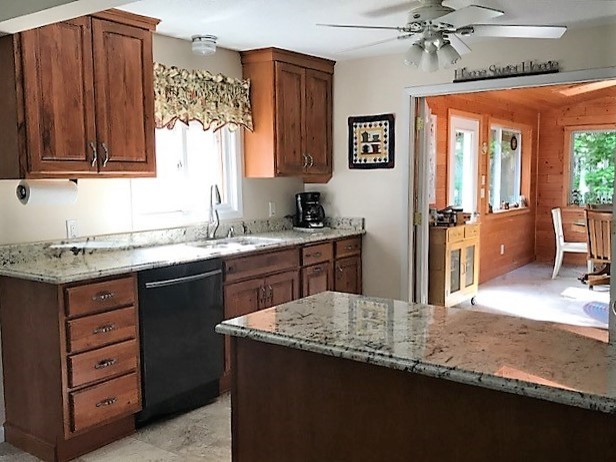 Example of a small transitional eat-in kitchen design with raised-panel cabinets, medium tone wood cabinets, granite countertops and a peninsula