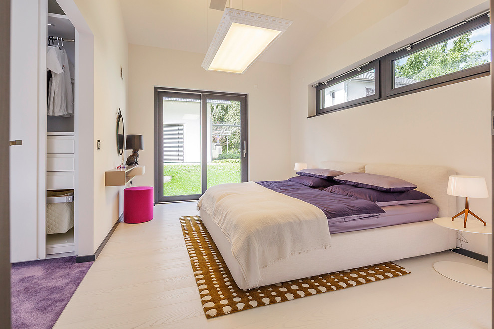 This is an example of a large contemporary master bedroom in Nuremberg with white walls, light hardwood floors and no fireplace.