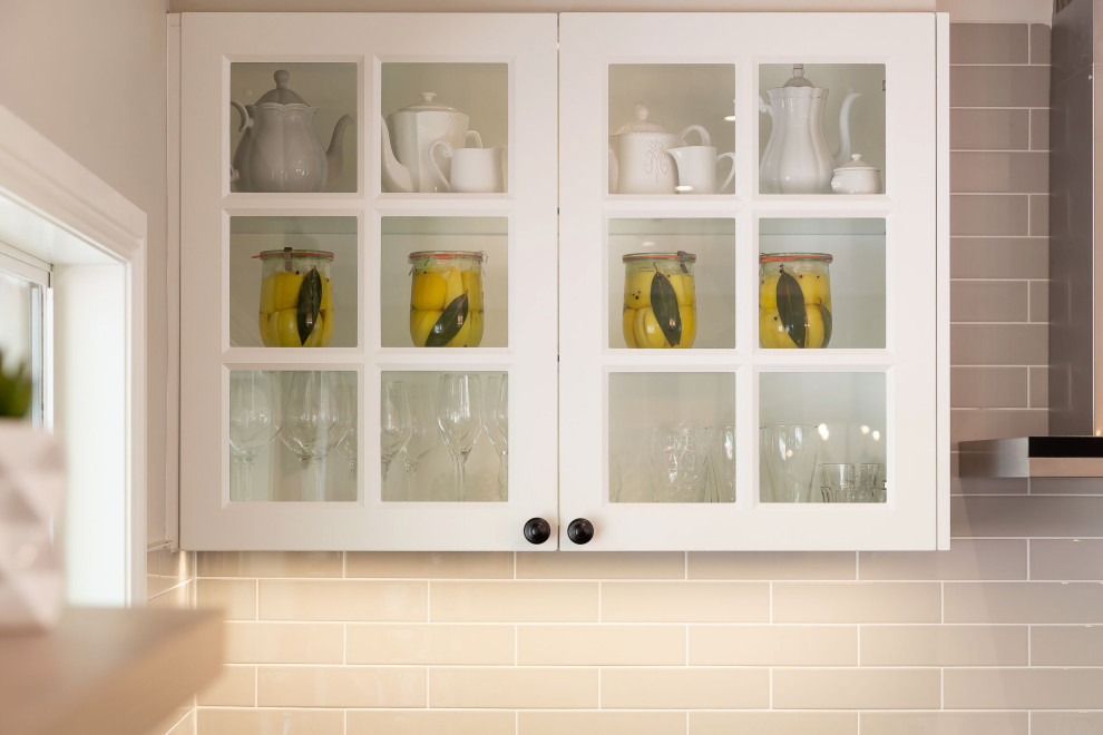 Inspiration for a traditional l-shaped open plan kitchen with a double-bowl sink, shaker cabinets, white cabinets, quartz benchtops, grey splashback, subway tile splashback, stainless steel appliances, vinyl floors, with island, brown floor and grey benchtop.