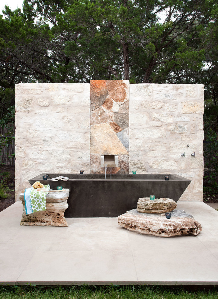 Patio fountain - contemporary side yard stone patio fountain idea in Austin with no cover