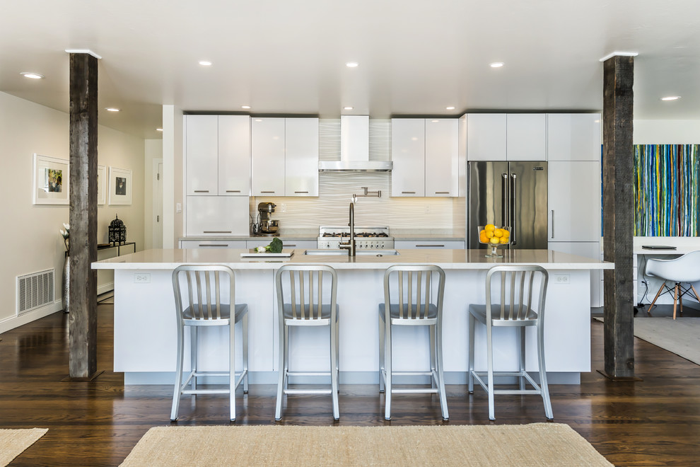 Mid-sized contemporary galley eat-in kitchen in San Francisco with an undermount sink, flat-panel cabinets, white cabinets, quartz benchtops, white splashback, ceramic splashback, stainless steel appliances, medium hardwood floors and with island.