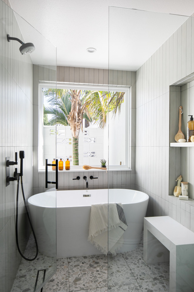 Пример оригинального дизайна: маленькая главная ванная комната в стиле ретро с фасадами цвета дерева среднего тона, отдельно стоящей ванной, душевой комнатой, унитазом-моноблоком, серой плиткой, керамической плиткой, белыми стенами, полом из керамической плитки, врезной раковиной, столешницей из искусственного кварца, разноцветным полом, душем с распашными дверями, белой столешницей, сиденьем для душа, тумбой под одну раковину и встроенной тумбой для на участке и в саду