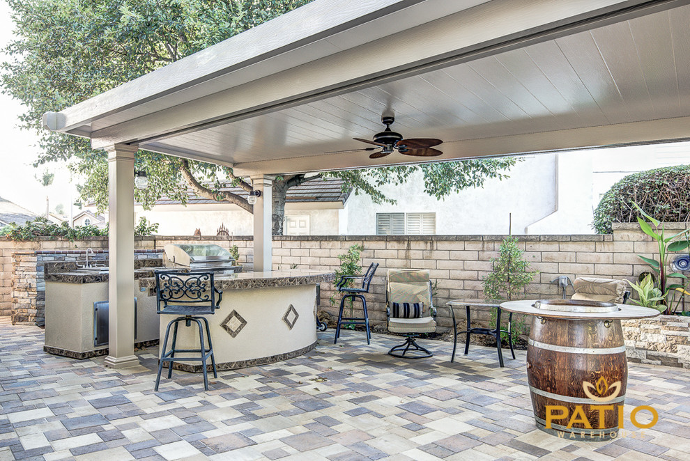 This is an example of a traditional backyard patio in Orange County with concrete pavers and a gazebo/cabana.