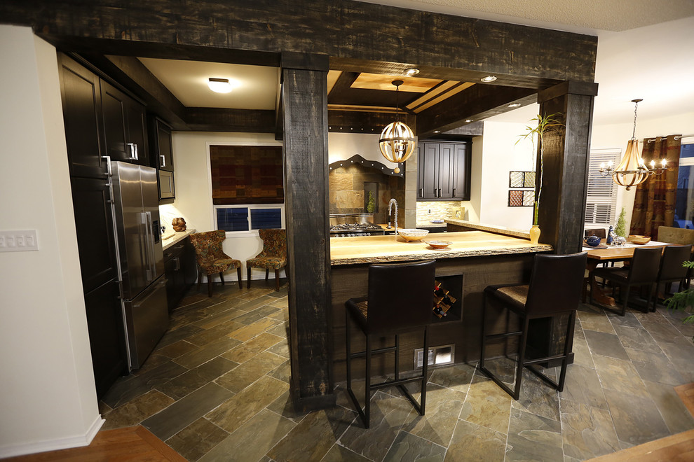 Design ideas for a large country galley open plan kitchen in Toronto with an undermount sink, shaker cabinets, dark wood cabinets, solid surface benchtops, multi-coloured splashback, stone tile splashback, stainless steel appliances, slate floors and with island.