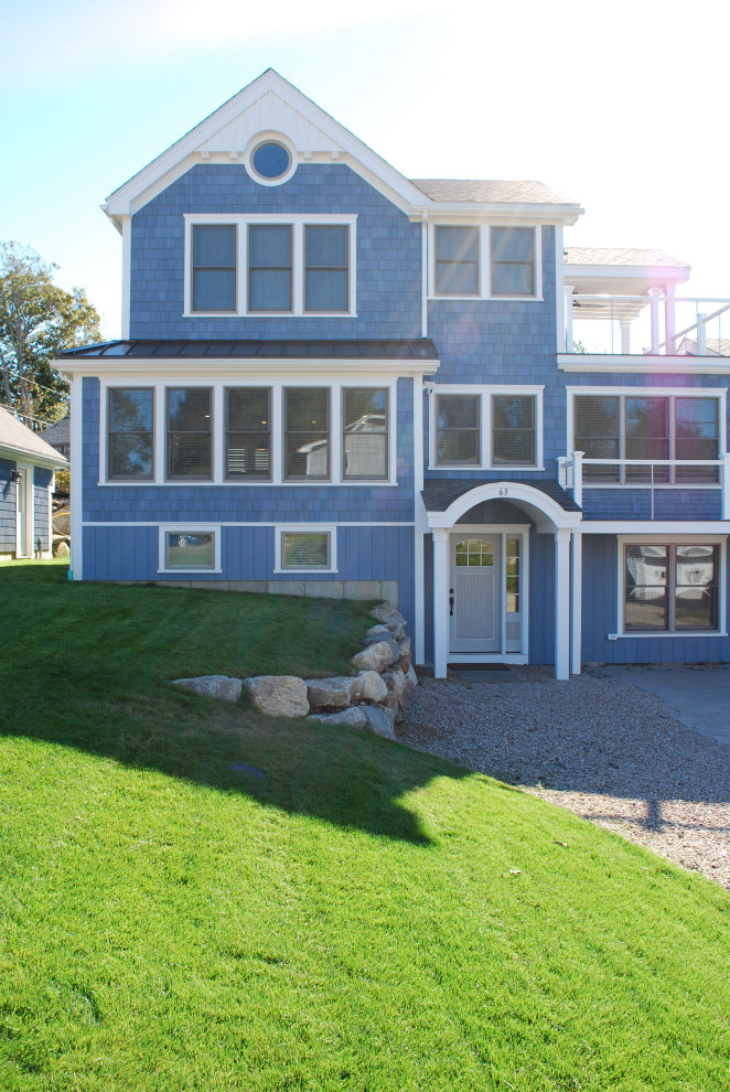 Foto della villa grande blu stile marinaro a tre piani con rivestimento in legno, falda a timpano e con scandole