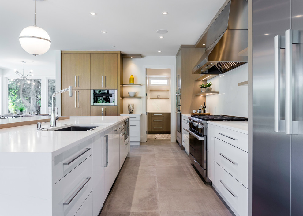 Large modern l-shaped open plan kitchen in Vancouver with an undermount sink, flat-panel cabinets, medium wood cabinets, quartzite benchtops, white splashback, stone slab splashback, stainless steel appliances, cement tiles, with island, grey floor and white benchtop.