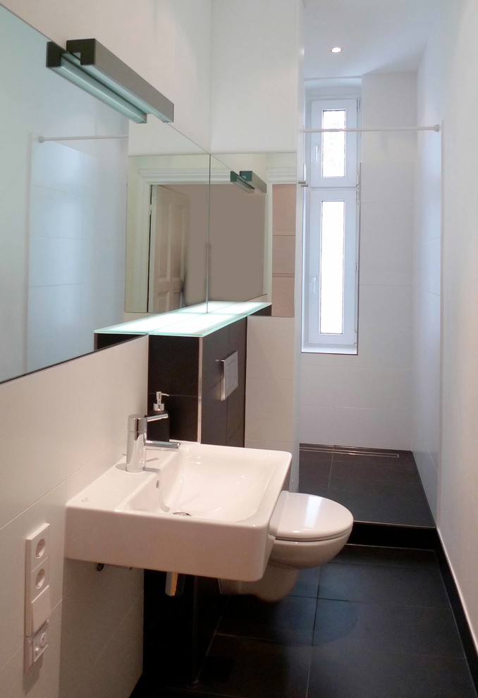 Photo of a small contemporary bathroom in Berlin with a two-piece toilet, black and white tile, ceramic tile, white walls and ceramic floors.